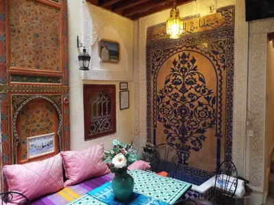 a room with a table and a large door at Dar Fès Huda in Fès