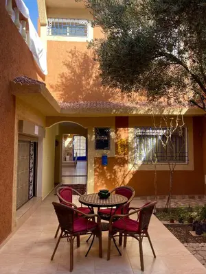 a patio with a table and chairs in front of a building at Dyafat Abla in Ouarzazate
