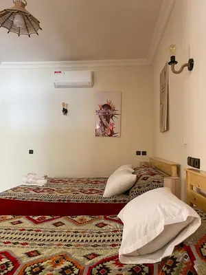 a bedroom with two beds and a ceiling at Dyafat Abla in Ouarzazate