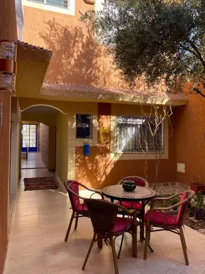 a patio with a table and chairs in front of a building at Dyafat Abla in Ouarzazate