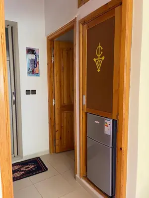 a kitchen with a refrigerator next to a door at Dyafat Abla in Ouarzazate