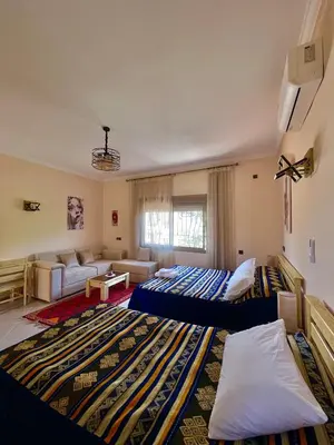 a large living room with two beds and a couch at Dyafat Abla in Ouarzazate