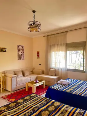 a living room with two beds and a couch at Dyafat Abla in Ouarzazate