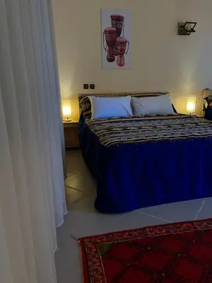 a bedroom with a bed with a blue comforter at Dyafat Abla in Ouarzazate