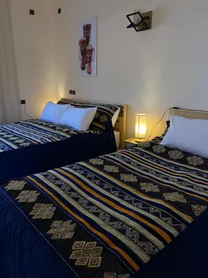 two beds sitting next to each other in a room at Dyafat Abla in Ouarzazate