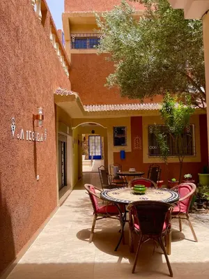 a patio with a table and chairs in a courtyard at Dyafat Abla in Ouarzazate