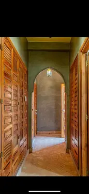 an empty hallway with wooden doors in a house at Riad du Bab atlas in Marrakech