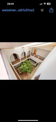 a picture of a building with a tree in the middle at Riad du Bab atlas in Marrakech