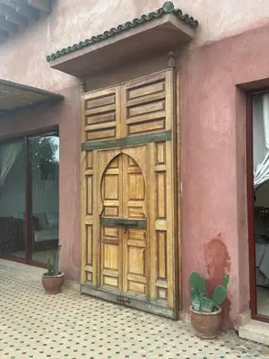 a wooden door on the side of a house at Riad du Bab atlas in Marrakech