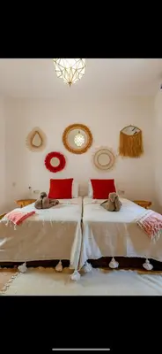 a bedroom with two beds with red pillows at Riad du Bab atlas in Marrakech