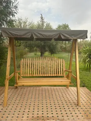 a wooden bench with a covering on top of it at Riad du Bab atlas in Marrakech