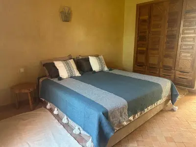 a bedroom with a bed with a blue blanket on it at Riad du Bab atlas in Marrakech