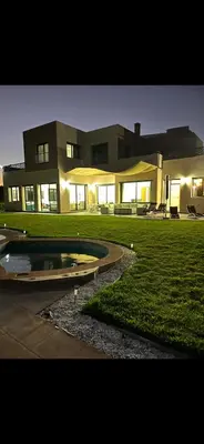 a large house with a pond in front of it at Perfekt villa Marrakech in Marrakech