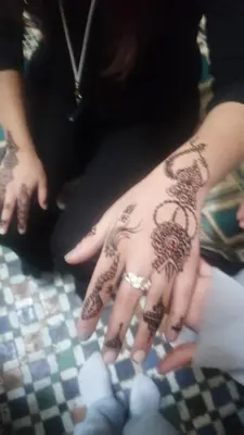 a woman with henna on her hands on a table at Dar lmallouki 1 in Fès