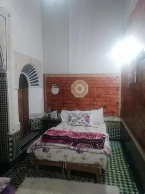 a bedroom with a bed and a brick wall at Dar lmallouki 1 in Fès