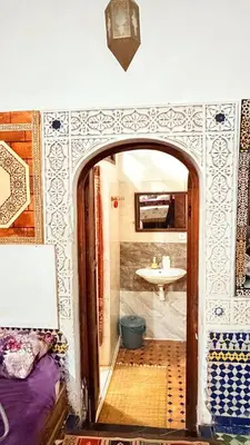 an archway in a room with a bathroom with a sink at Dar lmallouki 1 in Fès