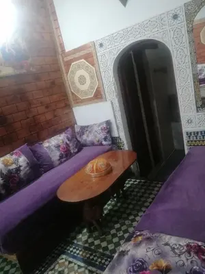 a room with a purple bed and a table at Dar lmallouki 1 in Fès