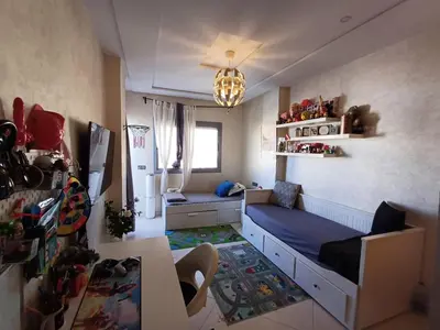 a small room with a bed and a refrigerator at Dar serenity in Meknès