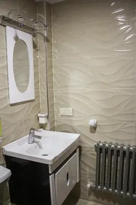 a bathroom with a sink and a mirror and a radiator at appartement amira ifrane in Ifrane
