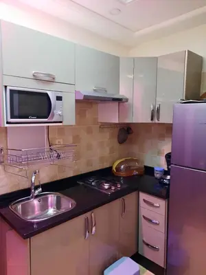 a kitchen with a sink and a stainless steel refrigerator at appartement amira ifrane in Ifrane