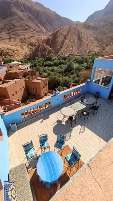 a patio with a table and chairs and mountains at Riad La Fleur in Aït Baha