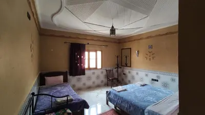 a bedroom with two beds and a window at Riad La Fleur in Aït Baha
