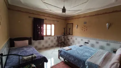 a bedroom with two beds and a window at Riad La Fleur in Aït Baha