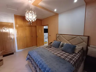 a bedroom with a bed and a chandelier at Belle vacances dans mon App in Meknès