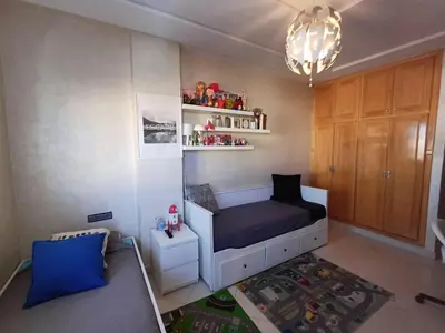 a small room with a bed and a chandelier at Belle vacances dans mon App in Meknès