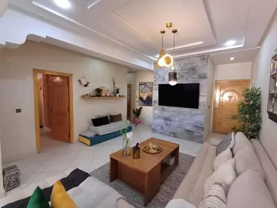 a living room with a couch and a table at Belle vacances dans mon App in Meknès