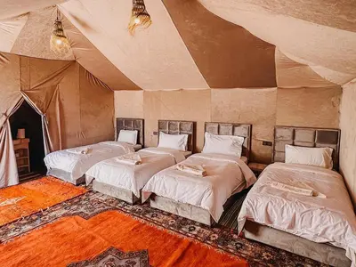 a room with three beds in a tent at Serenity Sky Luxury Camp in Merzouga