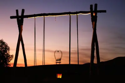 a view of a swing at sunset at Serenity Sky Luxury Camp in Merzouga