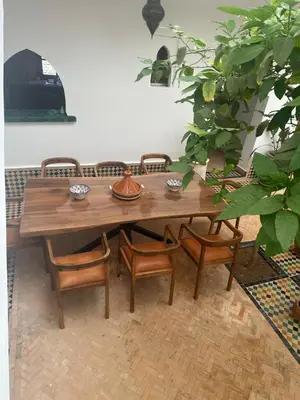 a wooden table and chairs in a room at Riad du Bab atlas in Marrakech