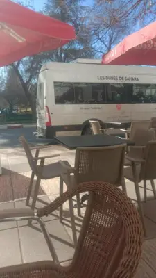a white bus driving past a table and chairs at Dolce Vita Nid Douillet alias Havre de Paix O Coeur d Ifrane in Ifrane