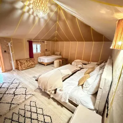 a bedroom with two beds in a tent at Sania Luxury Camp in Merzouga