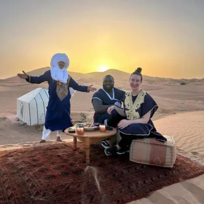 a man and a woman sitting in the desert at Sania Luxury Camp in Merzouga