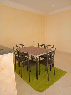 a dining room with a wooden table and chairs at Billa appart in Midelt