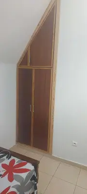 a large wooden cabinet in the corner of a room at Casa De La Mama chauffée cosy et climatisée 3 pièces Ifrane sous la neige in Ifrane