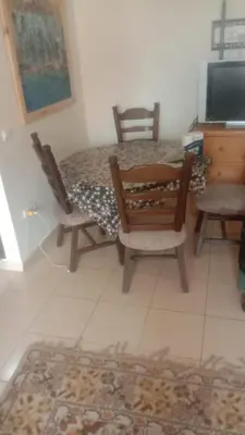 a room with a table and two chairs and a television at Casa De La Mama chauffée cosy et climatisée 3 pièces Ifrane sous la neige in Ifrane