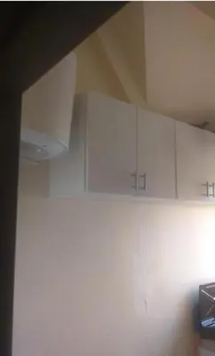 a kitchen with white cabinets on the wall at Vue Neige et Forêt Ifrane bien au chaud 3 pieces in Ifrane