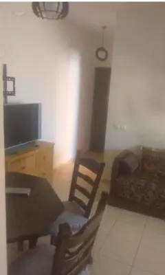 a living room with a table and a couch at Vue Neige et Forêt Ifrane bien au chaud 3 pieces in Ifrane