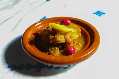 an orange bowl of food with a garnish on a table at Riad Zaya Fes in Fès