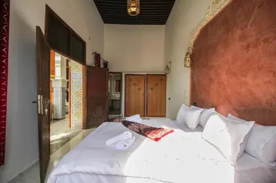 a bedroom with a large bed with white sheets at Riad Zaya Fes in Fès