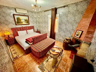 a bedroom with a bed and a couch at Auberge Sous Les Étoiles Lac Ouiouane in Kasba des Aït Athmane