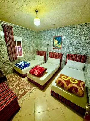 a room with two beds in a room at Auberge Sous Les Étoiles Lac Ouiouane in Kasba des Aït Athmane