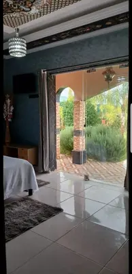 a bedroom with a large glass door to a patio at Villa Sarghini in Sidi Bouzguia