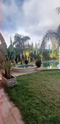a garden with a swimming pool in a yard at Villa Sarghini in Sidi Bouzguia