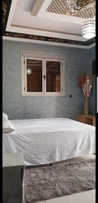 a bedroom with a white bed and a window at Villa Sarghini in Sidi Bouzguia