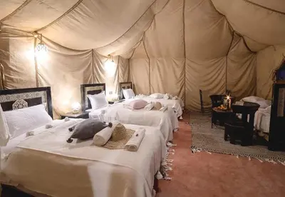 a room with four beds in a tent at Sands Charm Luxury Camp in Merzouga