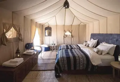 a bedroom with a large bed in a tent at Sands Charm Luxury Camp in Merzouga